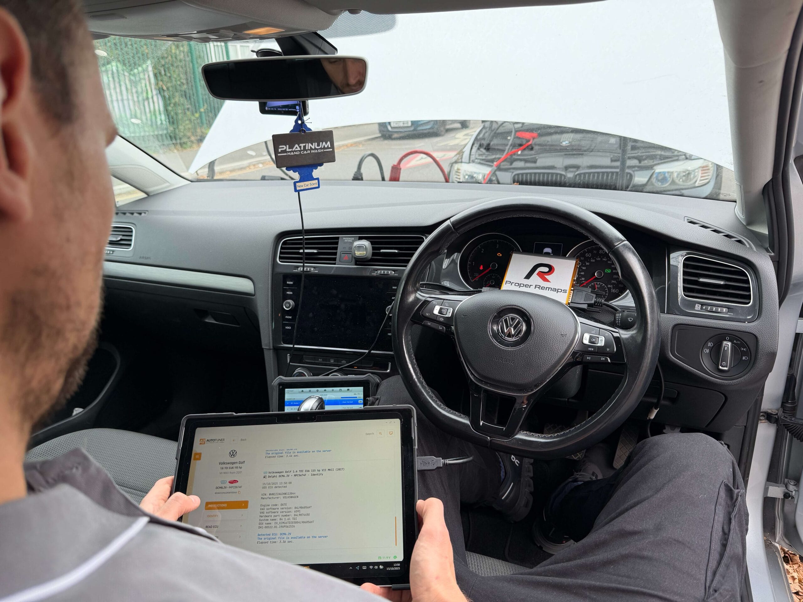 Technician is performing a Volkswagen Tuning via OBD whiles holding tablet